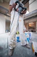 construction worker mixing plaster in bucket photo