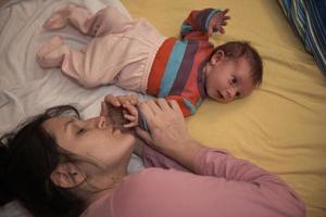 la madre está jugando con el bebé en casa foto