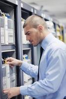 joven ingeniero informático en la sala de servidores del centro de datos foto