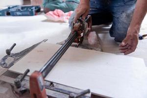 worker cutting the ceramic wood effect tiles photo