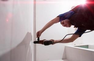 construction worker drilling holes in the bathroom photo