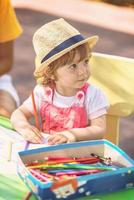 niña dibujando imágenes coloridas foto