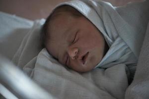 bebé recién nacido durmiendo en la cama en el hospital foto