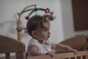 cute  little one year old baby and making first steps in bed photo