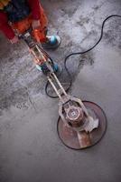 worker performing and polishing sand and cement screed floor photo