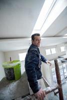 construction worker plastering on gypsum ceiling photo