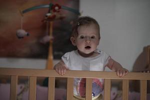 cute  little one year old baby and making first steps in bed photo