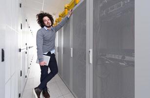 IT engineer working on a tablet computer in server room photo