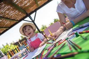 mamá y su pequeña hija dibujando imágenes coloridas foto