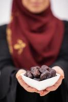 modern muslim woman holding a plate of dates in ramadan kareem photo