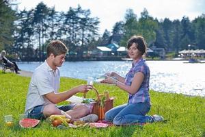 feliz pareja joven haciendo un picnic al aire libre foto