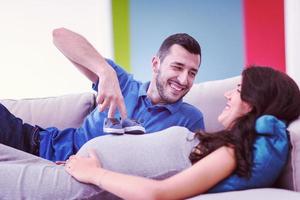 young pregnant couple relaxing on sofa photo