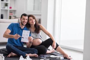 pregnant couple checking a list of things for their unborn baby photo