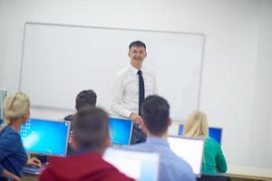 estudiantes con profesor en aula de laboratorio de computación foto