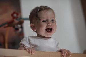 cute  little one year old baby and making first steps in bed photo