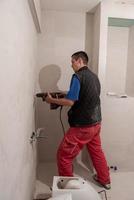 construction worker drilling holes in the bathroom photo
