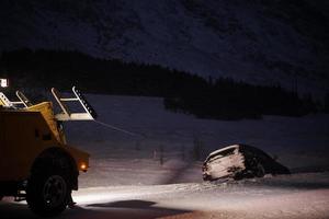 coche siendo remolcado después de un accidente en una tormenta de nieve foto