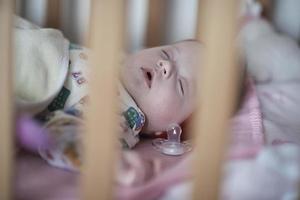 newborn baby sleeping  at home in bed photo