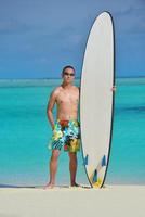 Man with surf board on beach photo