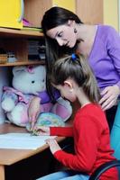 mamá y niña haciendo la tarea en casa foto