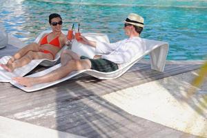 happy young couple relax and take fresh drink on poolside photo