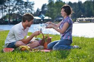 feliz pareja joven haciendo un picnic al aire libre foto