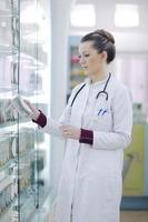 pharmacist chemist woman standing in pharmacy drugstore photo