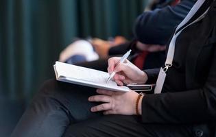 close up of business people taking notes photo