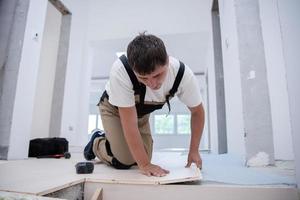 trabajador instalando un nuevo piso de madera laminada foto