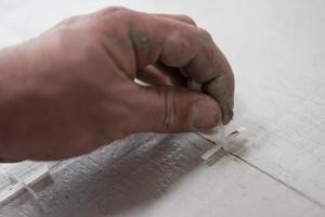 worker installing the ceramic wood effect tiles on the floor photo