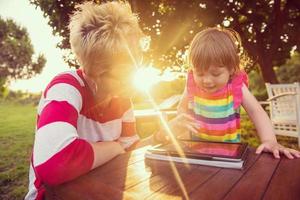 mom and her little daughter using tablet computer photo