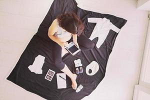 top view of pregnant woman checking list of baby clothes photo