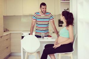 pareja comiendo fresas de frutas en la cocina foto