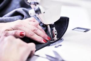 Hands of Seamstress Using Sewing Machine photo