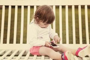 niña jugando con teléfono móvil foto