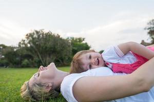 mother and little daughter playing at backyard photo