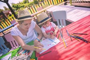 mom and little daughter drawing a colorful pictures photo