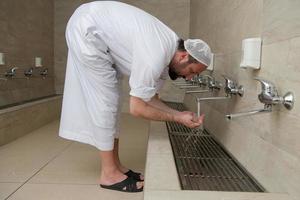 A Muslim takes ablution for prayer. Islamic religious rite photo