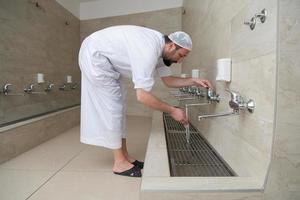 A Muslim takes ablution for prayer. Islamic religious rite photo