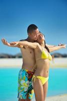 feliz pareja joven disfrutando del verano en la playa foto