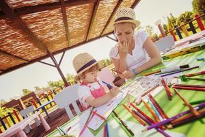 mamá y su pequeña hija dibujando imágenes coloridas foto