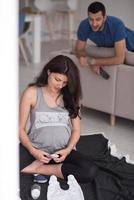 pareja embarazada revisando una lista de cosas para su bebé por nacer foto
