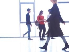 student girl standing with laptop, people group passing by photo