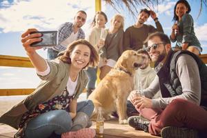 Group of friends having fun on autumn day at beach photo