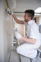 construction worker plastering on gypsum walls photo