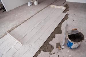 Ceramic wood effect tiles and tools for tiler on the floor photo