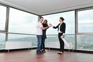 happy young couple buying new home with real estate agent photo