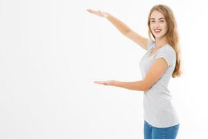 Portrait of smiling young blonde caucasian woman wearing summer t shirt pointing at copy space by hands isolated on white template and blank background. Advertising plase photo