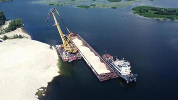 Aerial view of crushed stone being loaded onto a bulk carrier. video