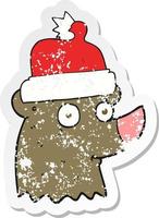 retro distressed sticker of a cartoon bear wearing christmas hat vector